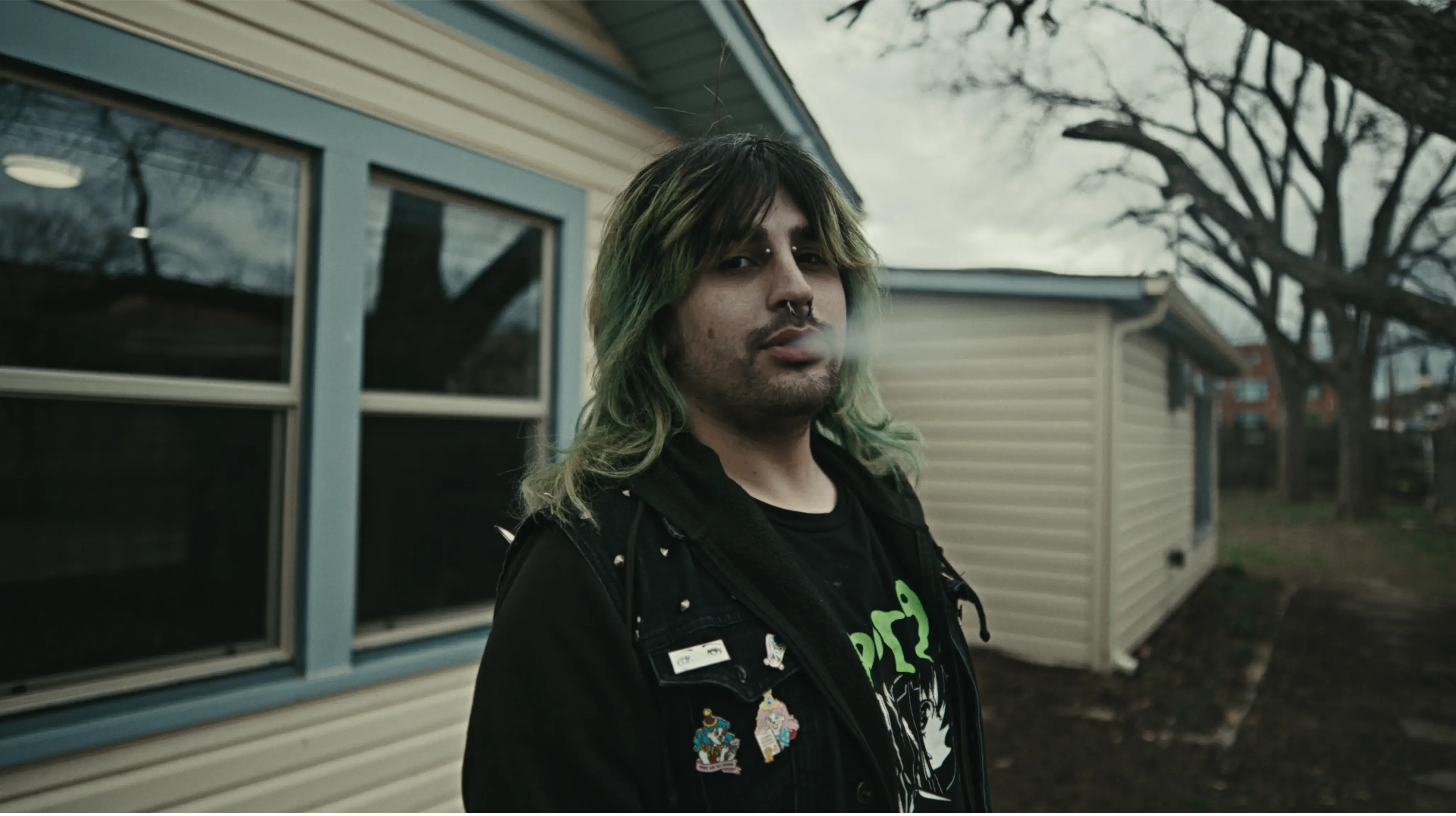 Man smoking outside a yellow house
